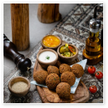 foto de um prato de falafel com diversos molhos